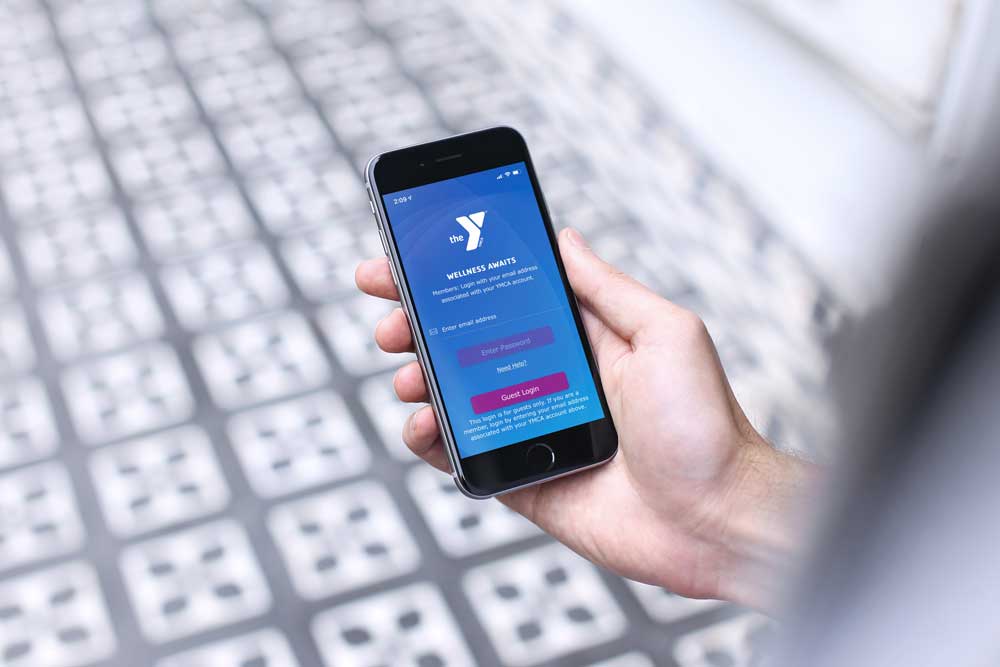 person holding phone with ymca app